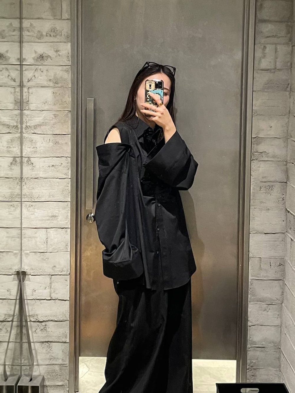 ブラック系のシャツ/ブラウスを着用したレディースの春コーディネートの2枚目の写真