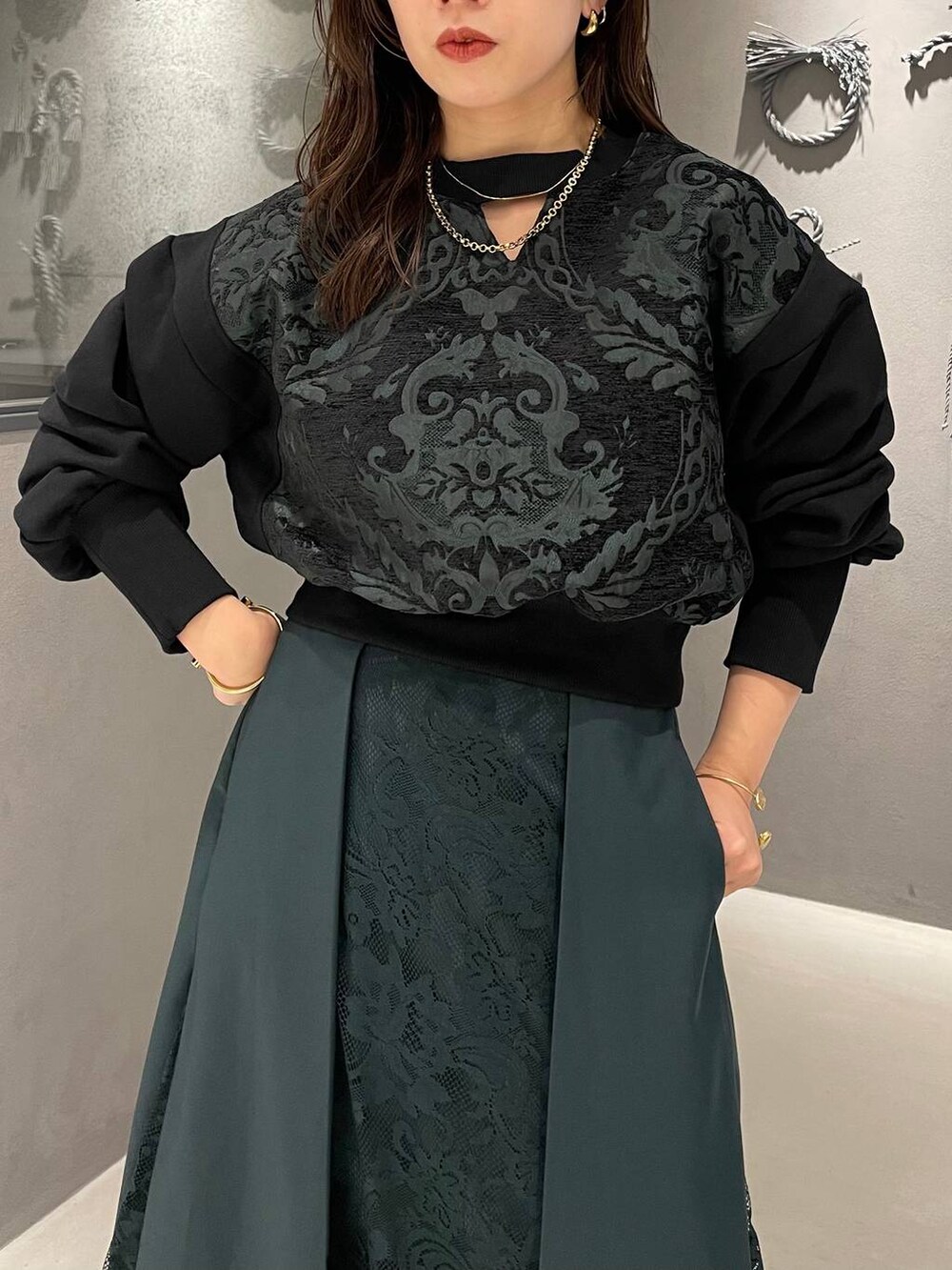 ブラック系のパンプス、グリーン系のスカート、グリーン系のスウェットを着用したレディースの夏コーディネートの4枚目の写真