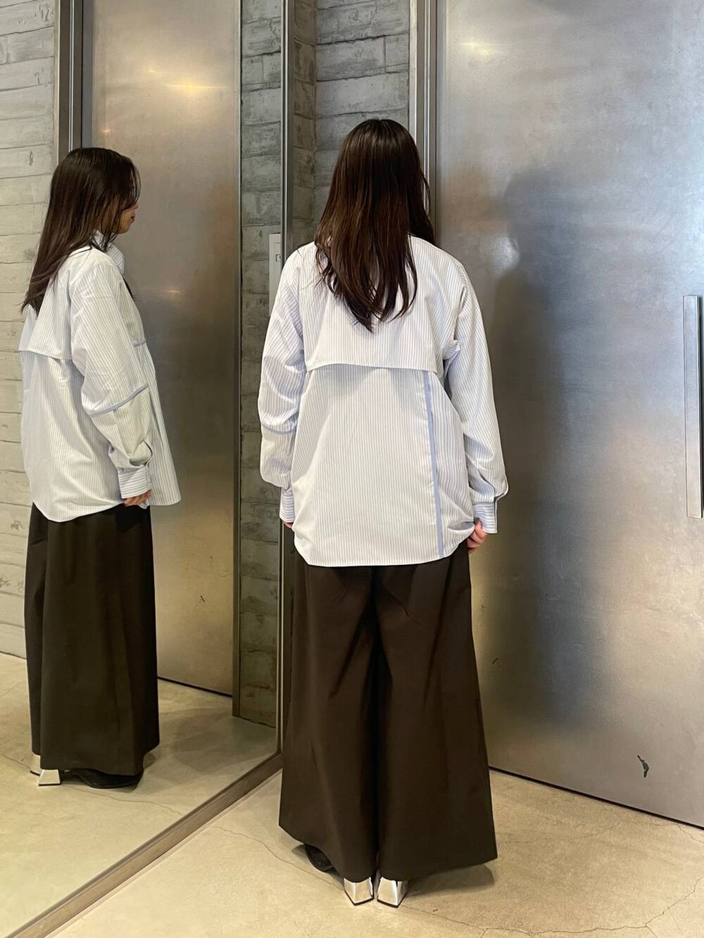 ブラック系のネクタイ、ブラック系のブーツ、ブルー系のシャツ/ブラウスを着用したレディースの春コーディネートの3枚目の写真