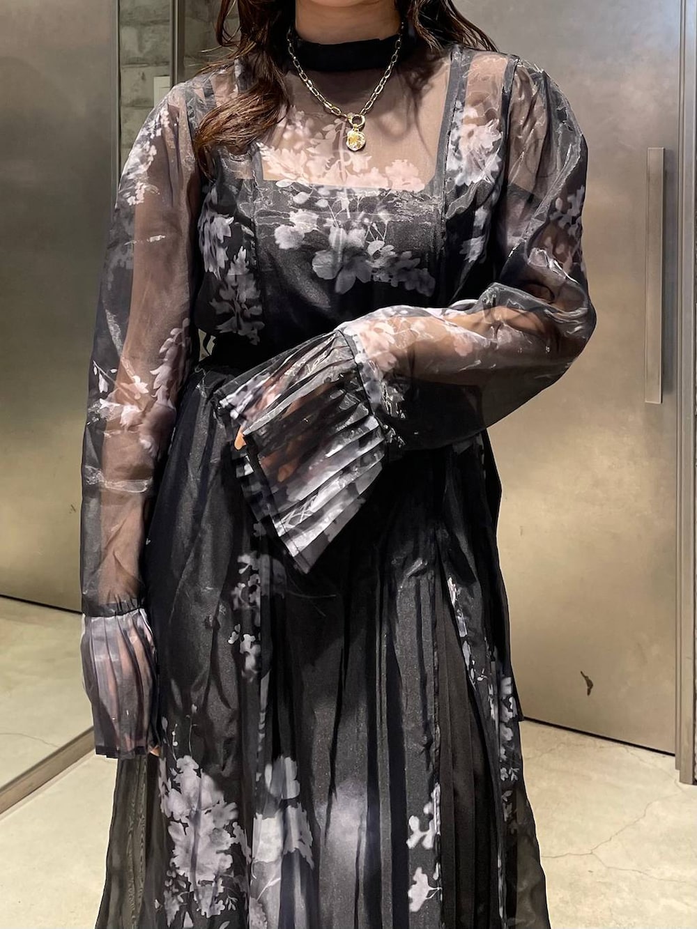 ブラック系のパンプス、ブラック系のワンピース、ゴールド系のネックレスを着用したレディースの冬コーディネートの5枚目の写真