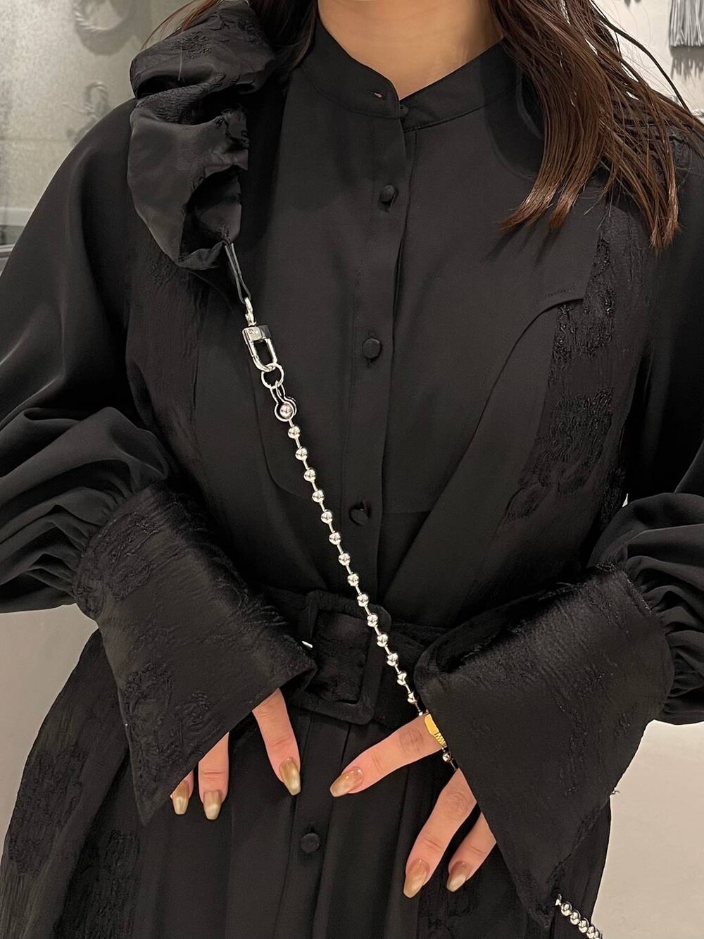 ブラック系のブーツ、ブラック系のワンピース、ブラック系のスマホグッズを着用したレディースの冬コーディネートの6枚目の写真