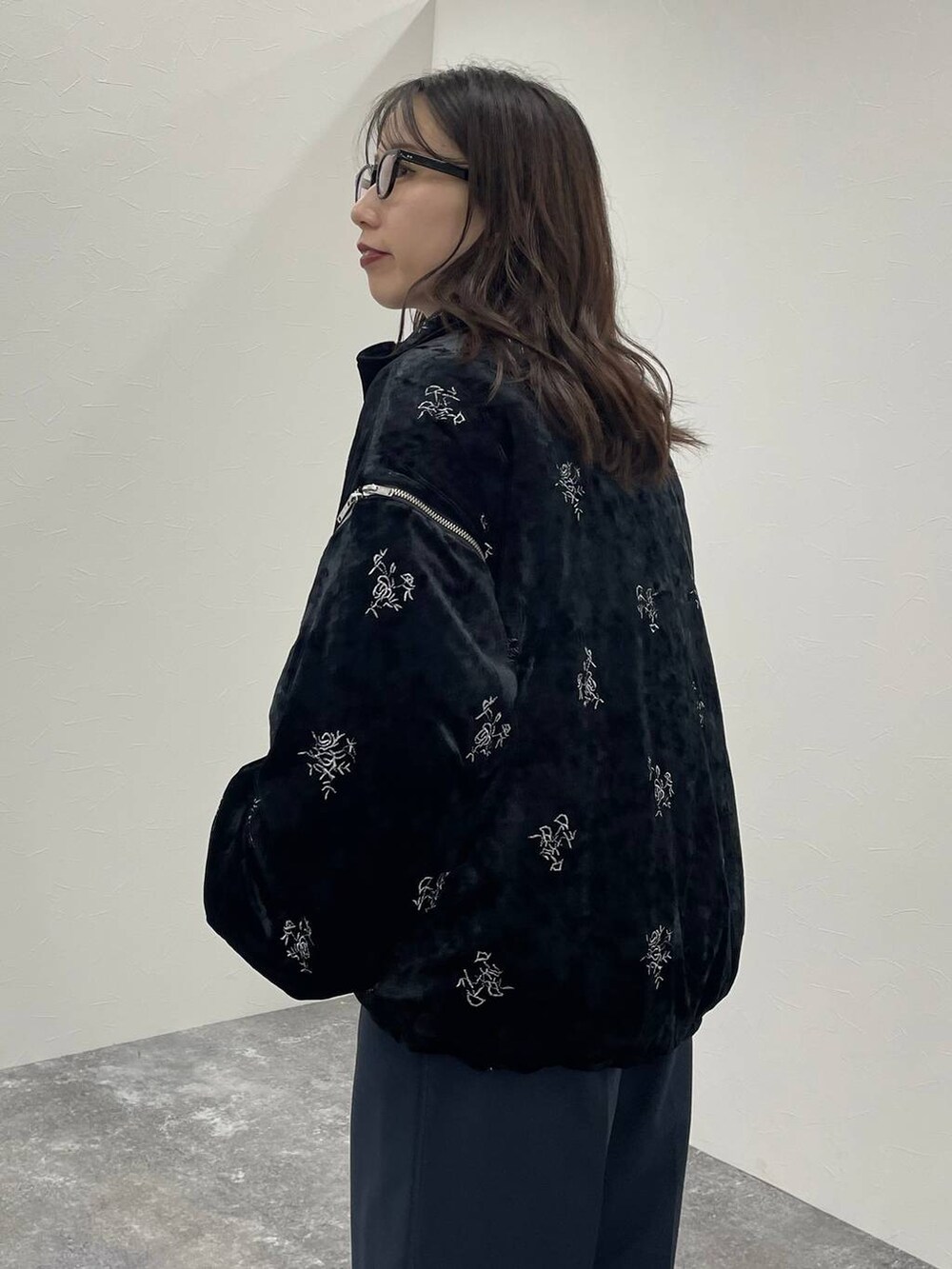 ブラック系のブルゾン、ブラック系のブーツ、ブラック系のスラックスを着用したレディースの秋コーディネートの4枚目の写真