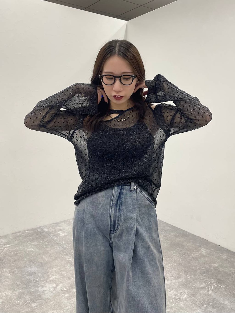 ブラック系のキャミソール、ブルー系のデニムパンツ、ブラック系のサンダルを着用したレディースの夏コーディネートの4枚目の写真