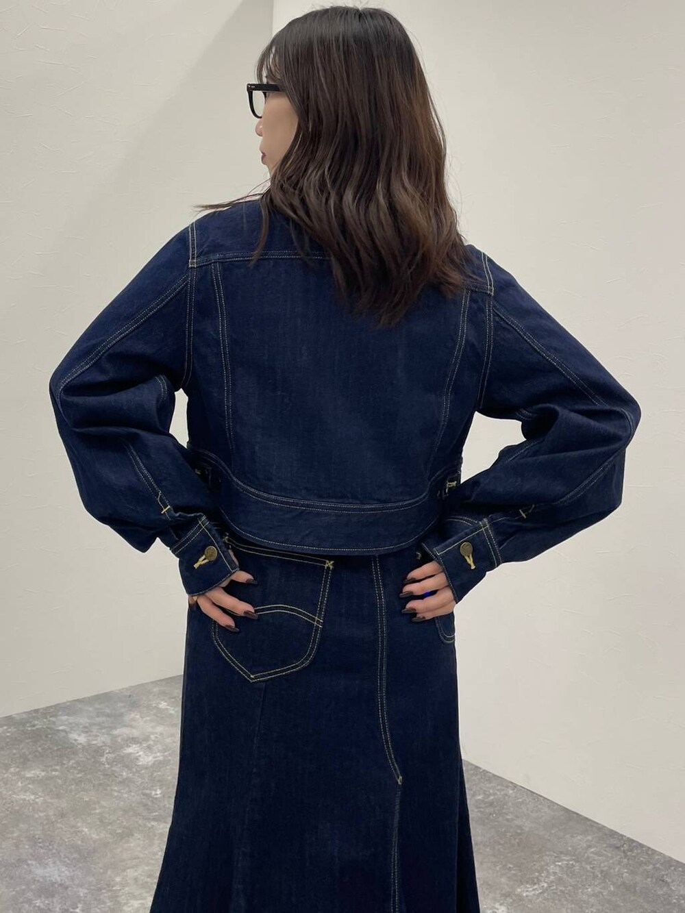 ブルー系のデニムジャケット、ブラック系のブーツ、ブルー系のデニムスカートを着用したレディースの秋コーディネートの7枚目の写真