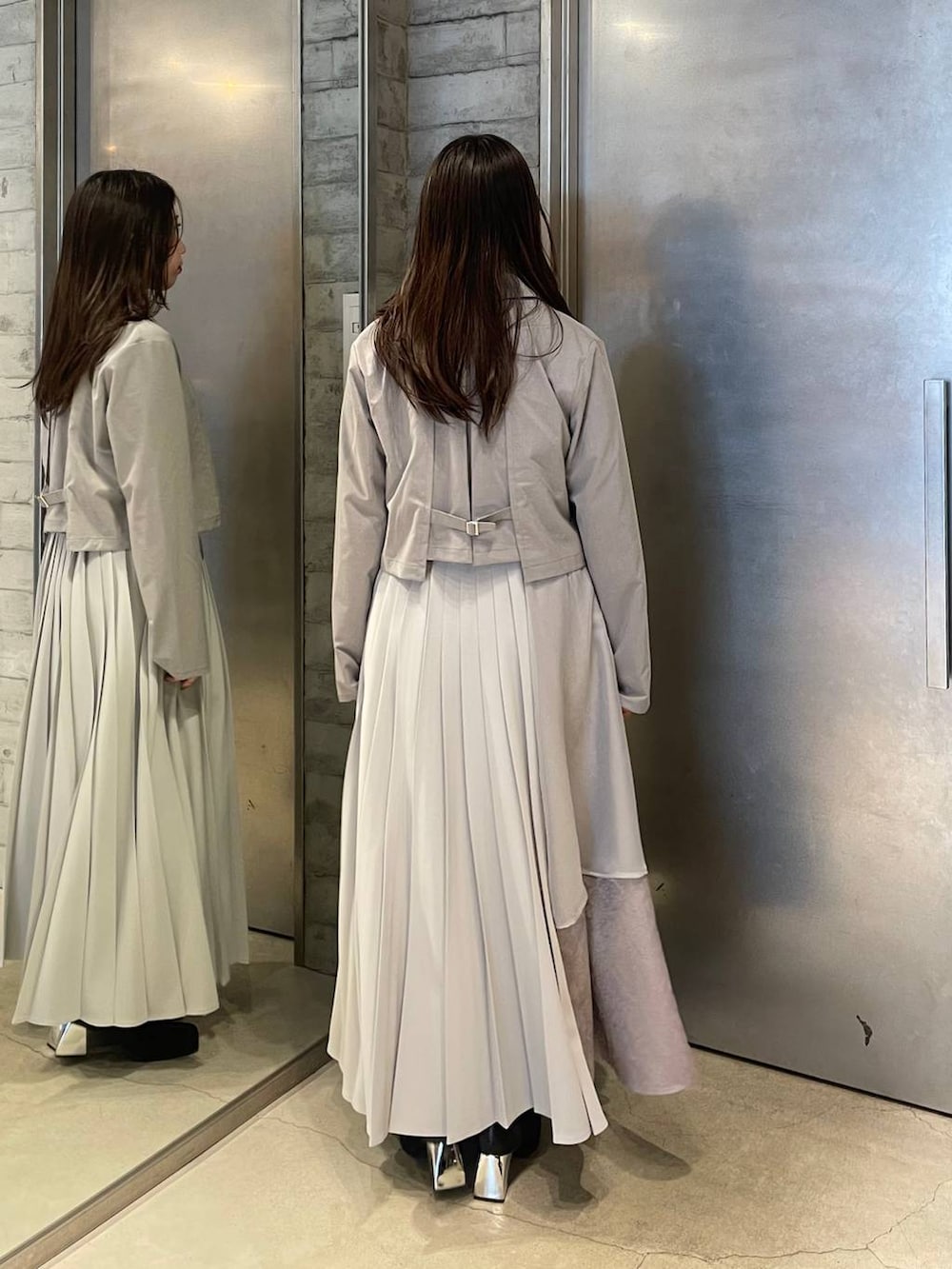 ブラック系のブーツ、グレー系のスカート、グレー系のテーラードジャケットを着用したレディースの春コーディネートの3枚目の写真