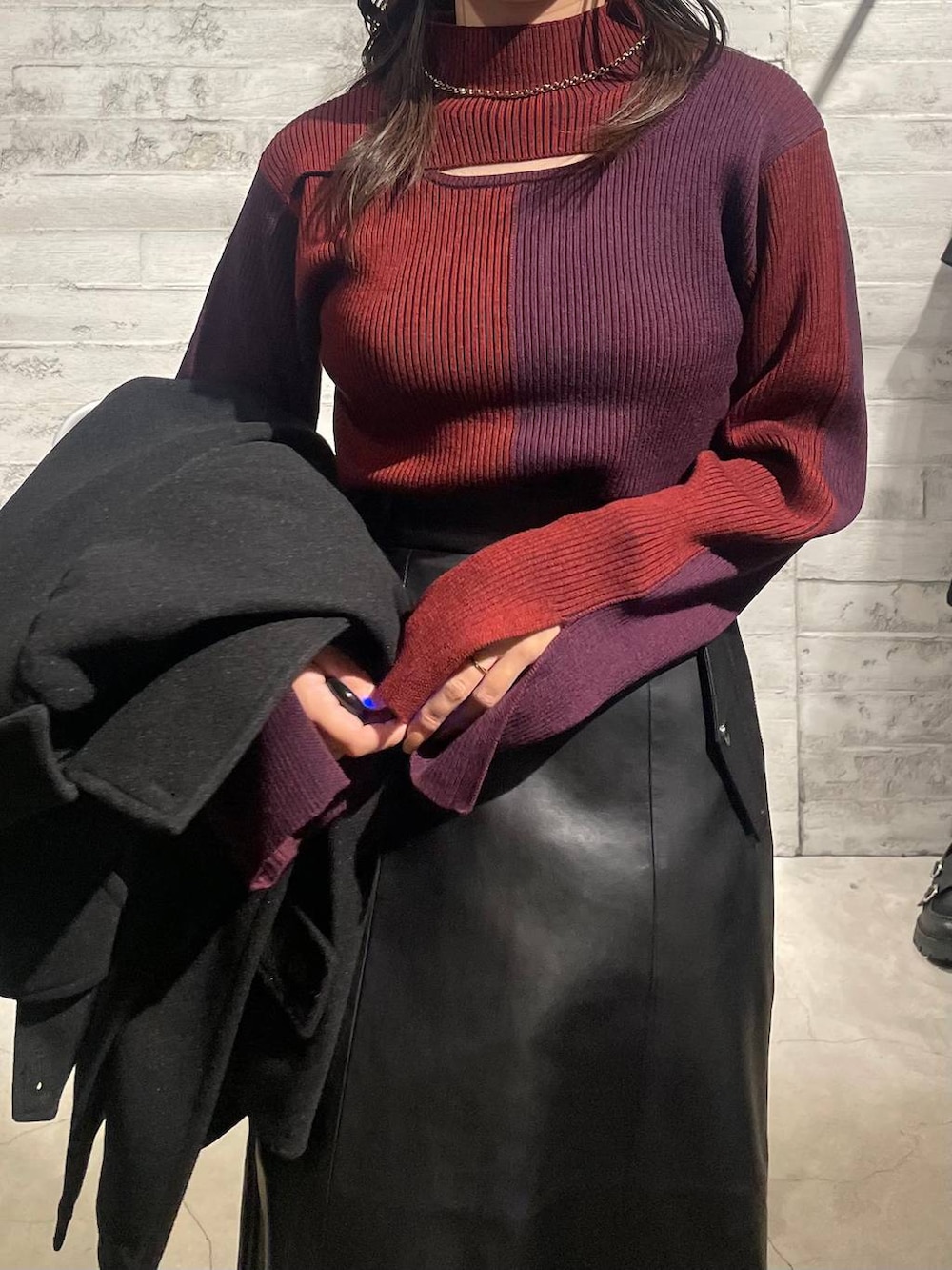 ブラック系のトレンチコート、ブラック系のブーツ、レッド系のニット/セーターを着用したレディースの秋コーディネートの6枚目の写真