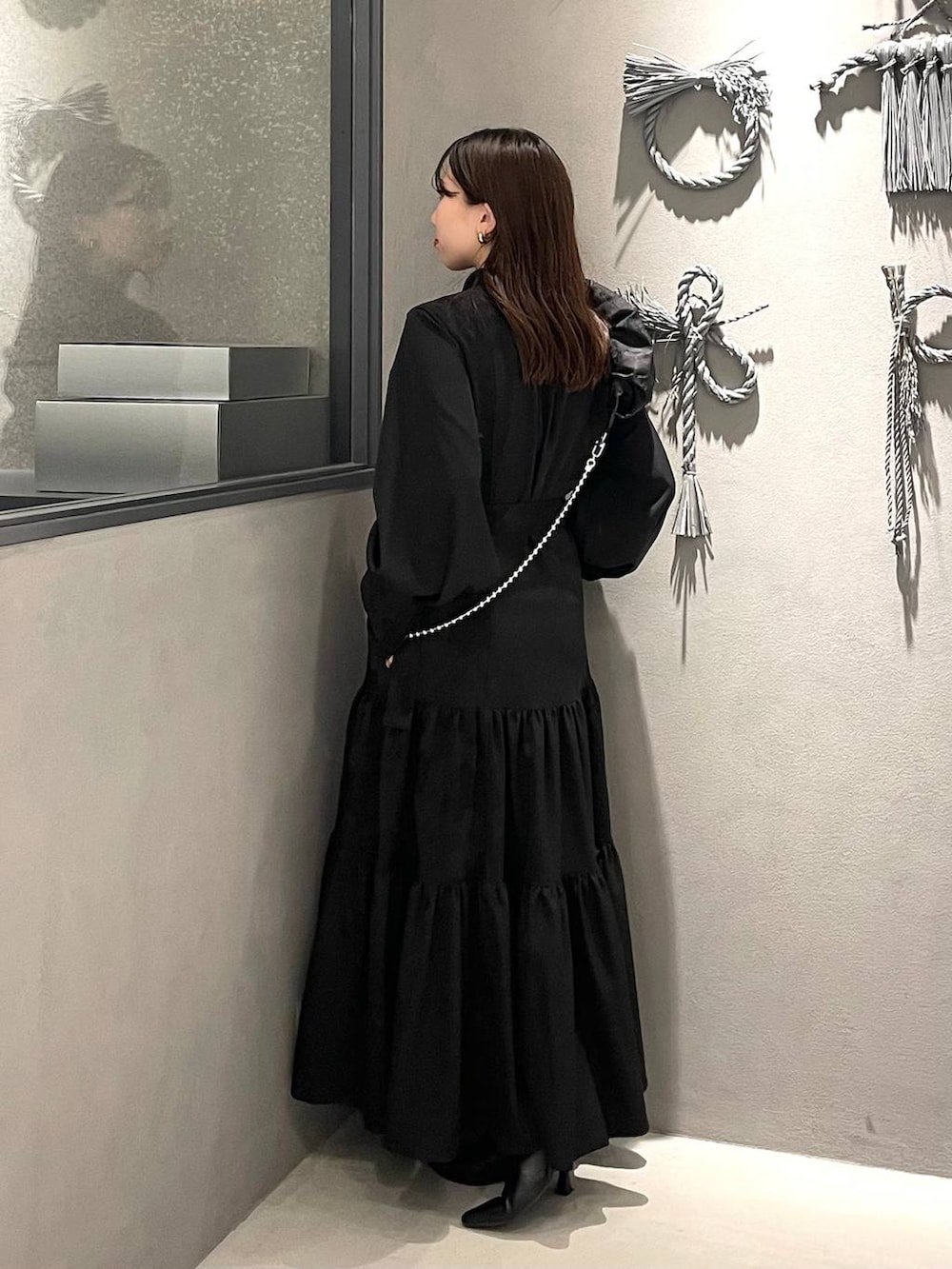 ブラック系のブーツ、ブラック系のワンピース、ブラック系のスマホグッズを着用したレディースの冬コーディネートの2枚目の写真