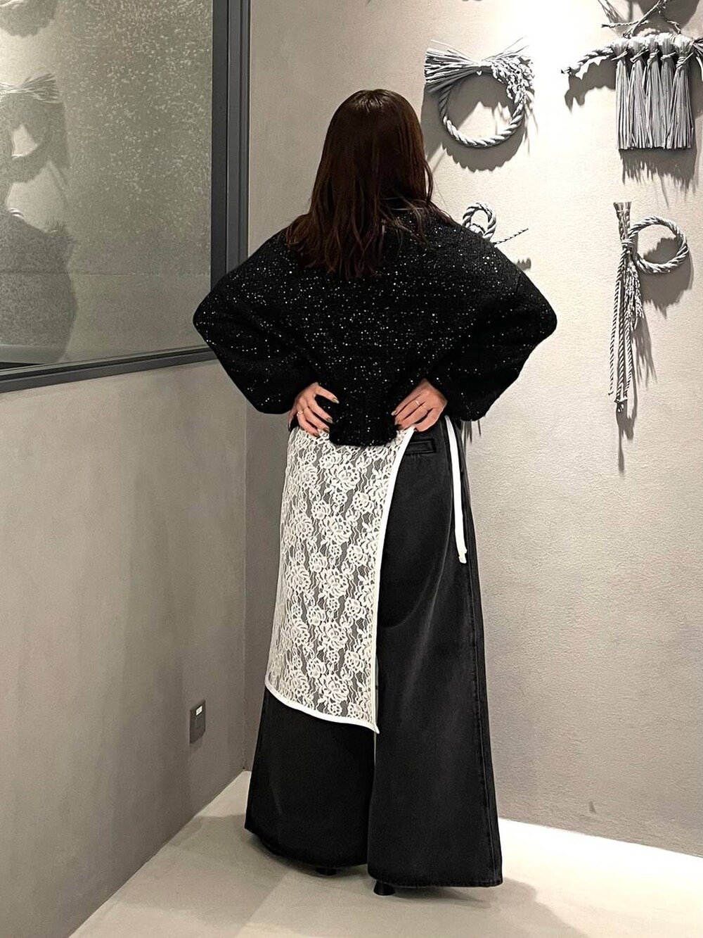 ブラック系のパンプス、ブラック系のニット/セーター、ブラック系のデニムパンツを着用したレディースの秋コーディネートの3枚目の写真