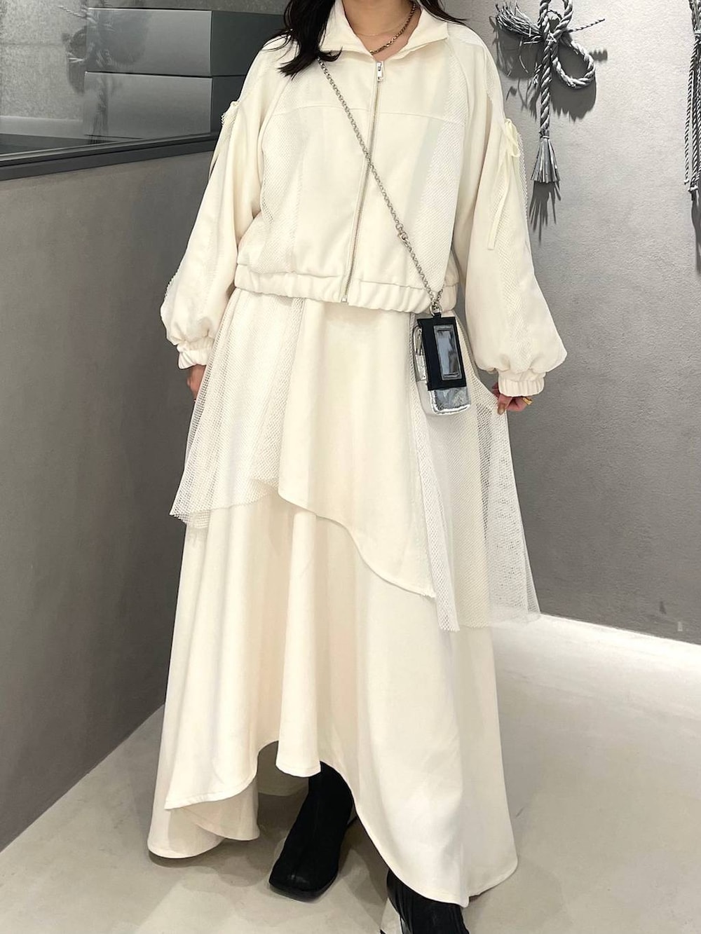 ブラック系のブーツ、ホワイト系のスカート、ホワイト系のブルゾンを着用したレディースの冬コーディネートの4枚目の写真