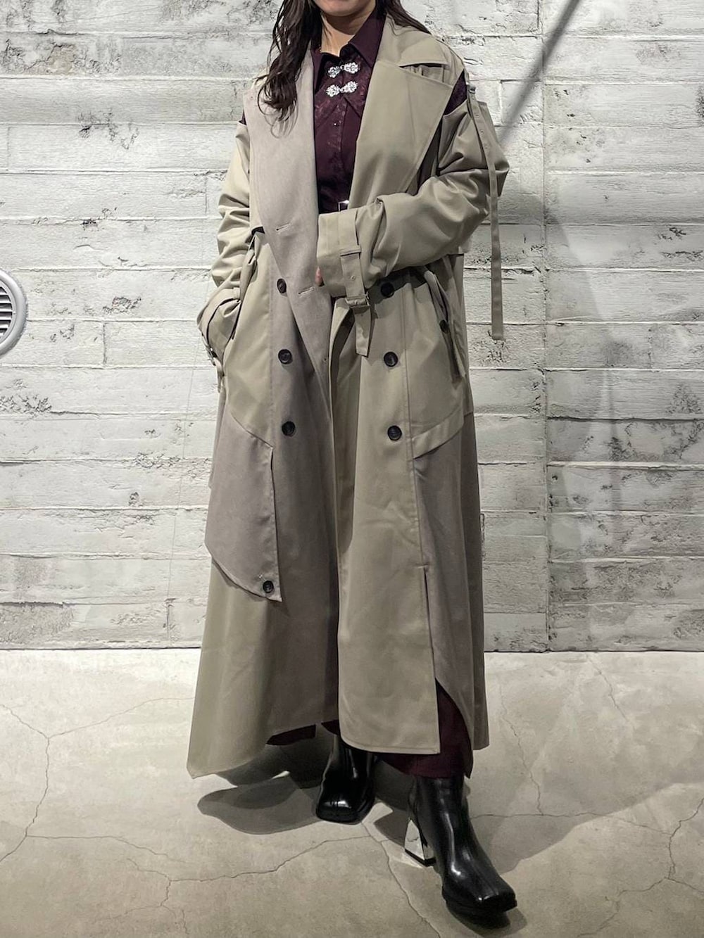 ブラック系のブーツ、レッド系のワンピース、ベージュ系のトレンチコートを着用したレディースの冬コーディネートの4枚目の写真