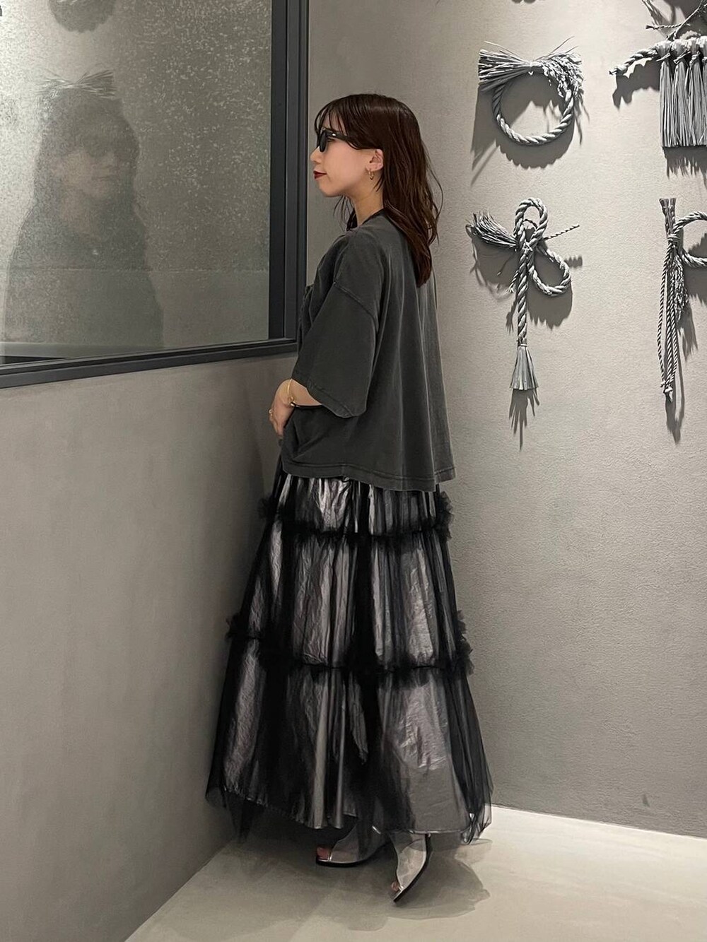 シルバー系のサンダル、シルバー系のスカート、ブラック系のTシャツ/カットソーを着用したレディースの春コーディネートの2枚目の写真