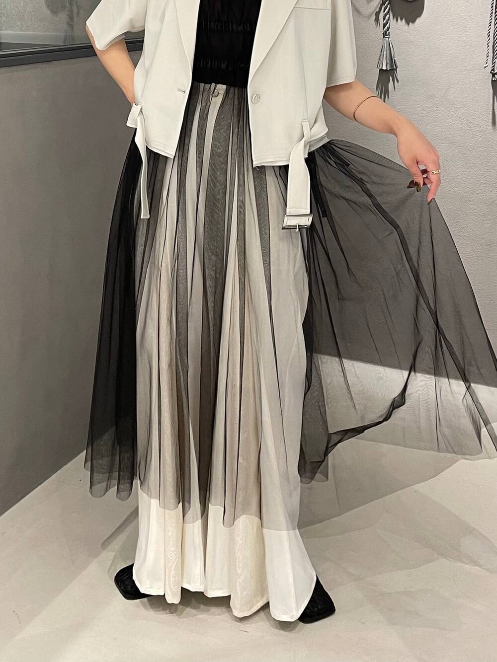 ブラック系のブーツ、ブラック系のタンクトップ、ブラック系のスカートを着用したレディースの夏コーディネートの5枚目の写真