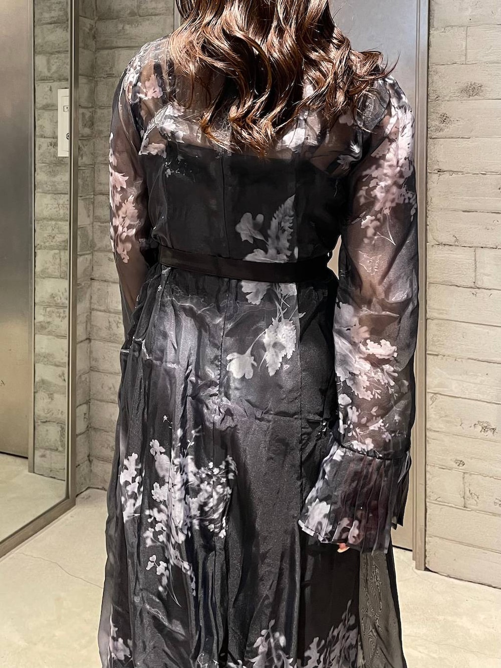 ブラック系のパンプス、ブラック系のワンピース、ゴールド系のネックレスを着用したレディースの冬コーディネートの6枚目の写真