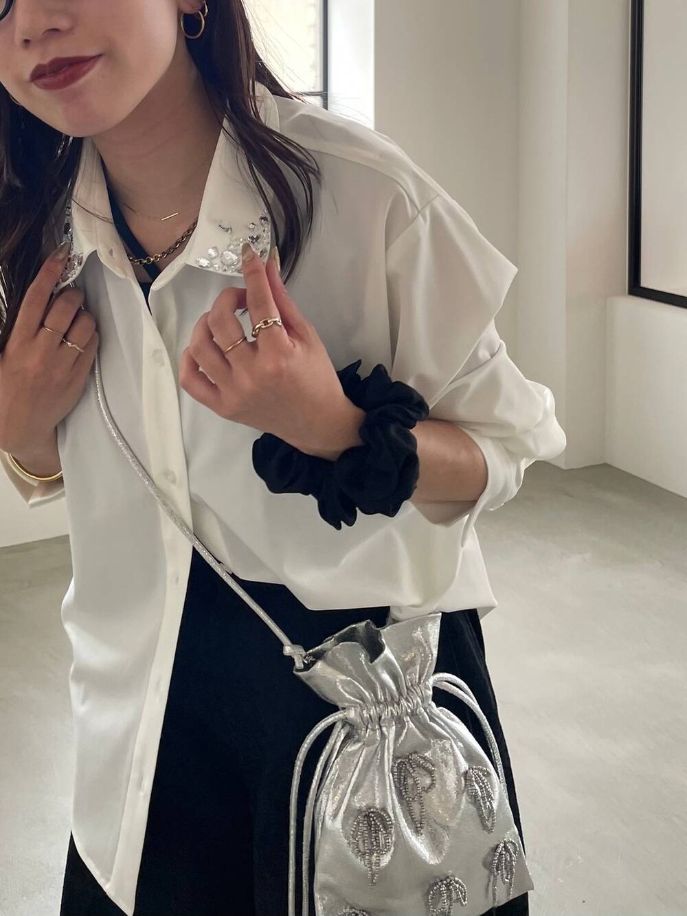 ブラック系のタンクトップ、ブラック系のブーツ、シルバー系のショルダーバッグを着用したレディースの夏コーディネートの4枚目の写真