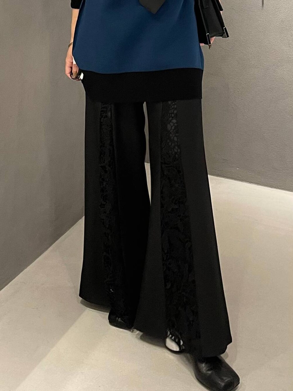 ブラック系のネクタイ、ブラック系のブーツ、ブラック系のショルダーバッグを着用したレディースの秋コーディネートの5枚目の写真