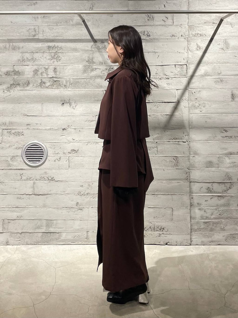 ブラック系のブーツ、ブラック系のTシャツ/カットソー、レッド系のスカートを着用したレディースの冬コーディネートの3枚目の写真