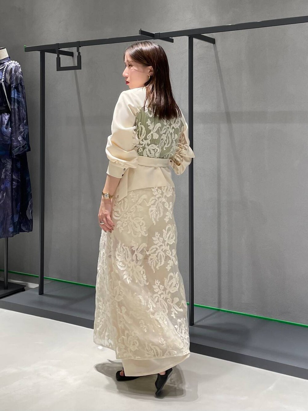 イエロー系のタンクトップ、ホワイト系のワンピース、ホワイト系のその他パンツを着用したレディースの春コーディネートの2枚目の写真