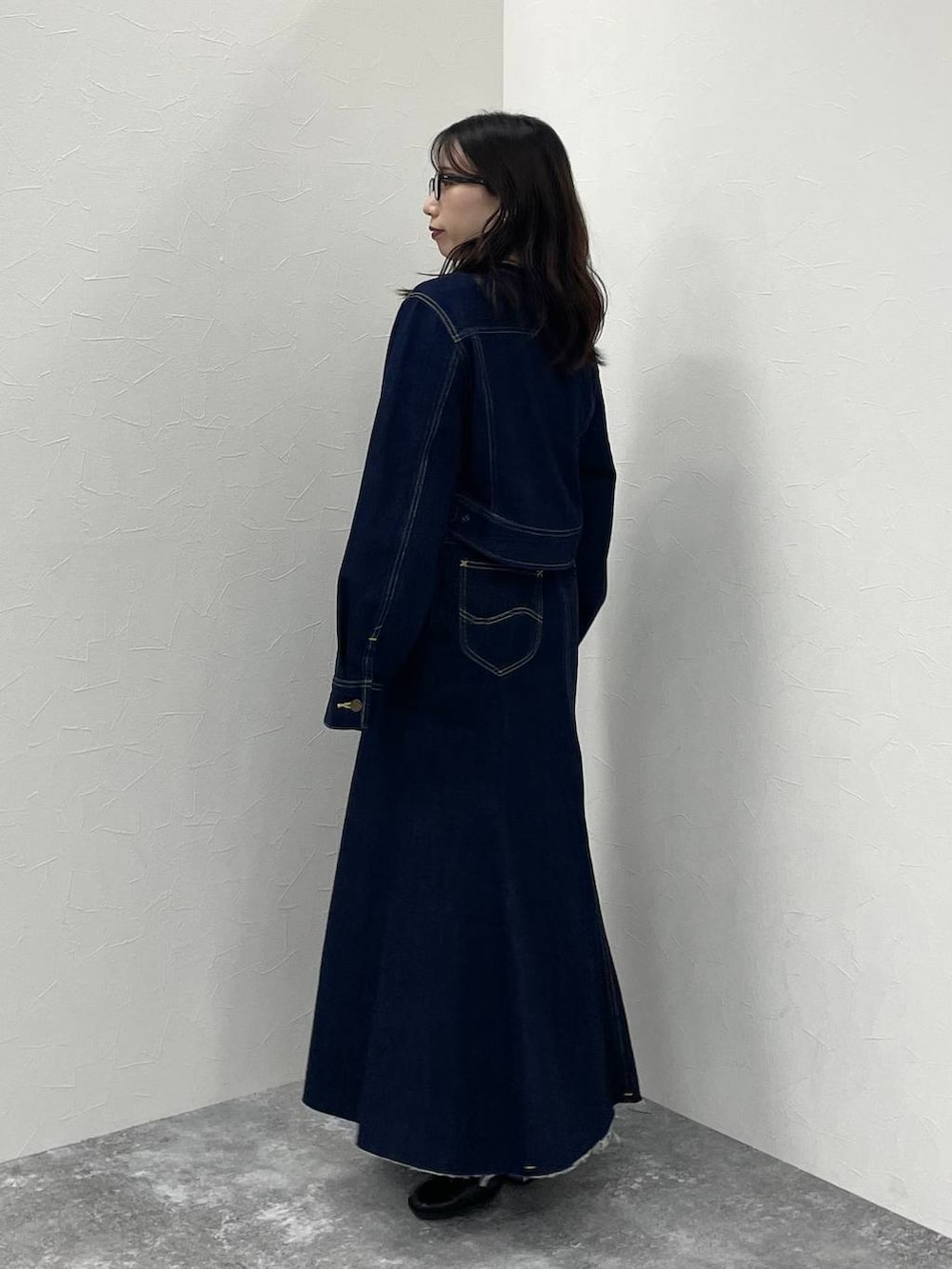 ブルー系のデニムジャケット、ブラック系のブーツ、ブルー系のデニムスカートを着用したレディースの秋コーディネートの3枚目の写真