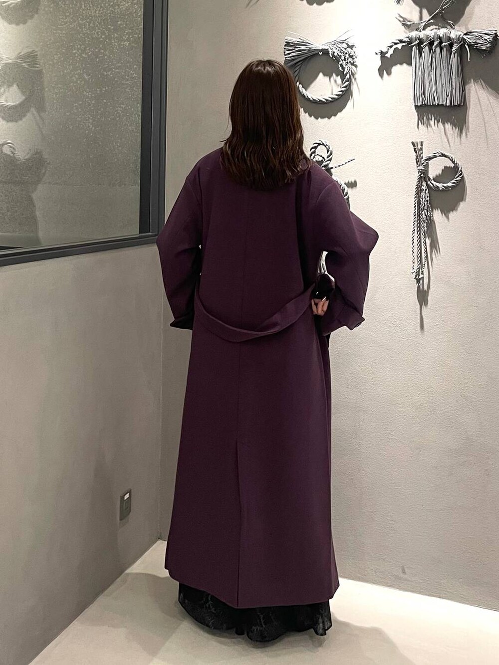 パープル系のチェスターコート、ブラック系のブーツ、レッド系のニット/セーターを着用したレディースの秋コーディネートの3枚目の写真