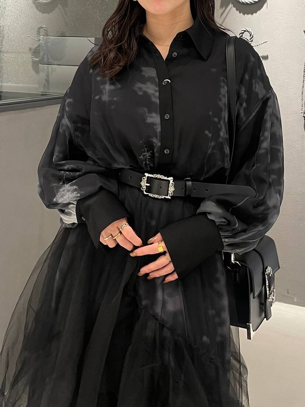 ブラック系のブーツ、ブラック系のショルダーバッグ、ブラック系のスカートを着用したレディースの冬コーディネートの4枚目の写真