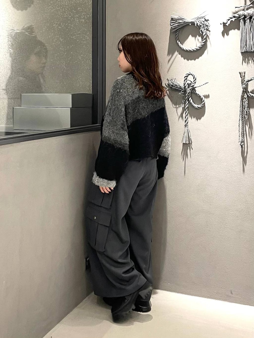 グレー系のカーゴパンツ、ブラック系のブーツ、ブルー系のシャツ/ブラウスを着用したレディースの冬コーディネートの2枚目の写真