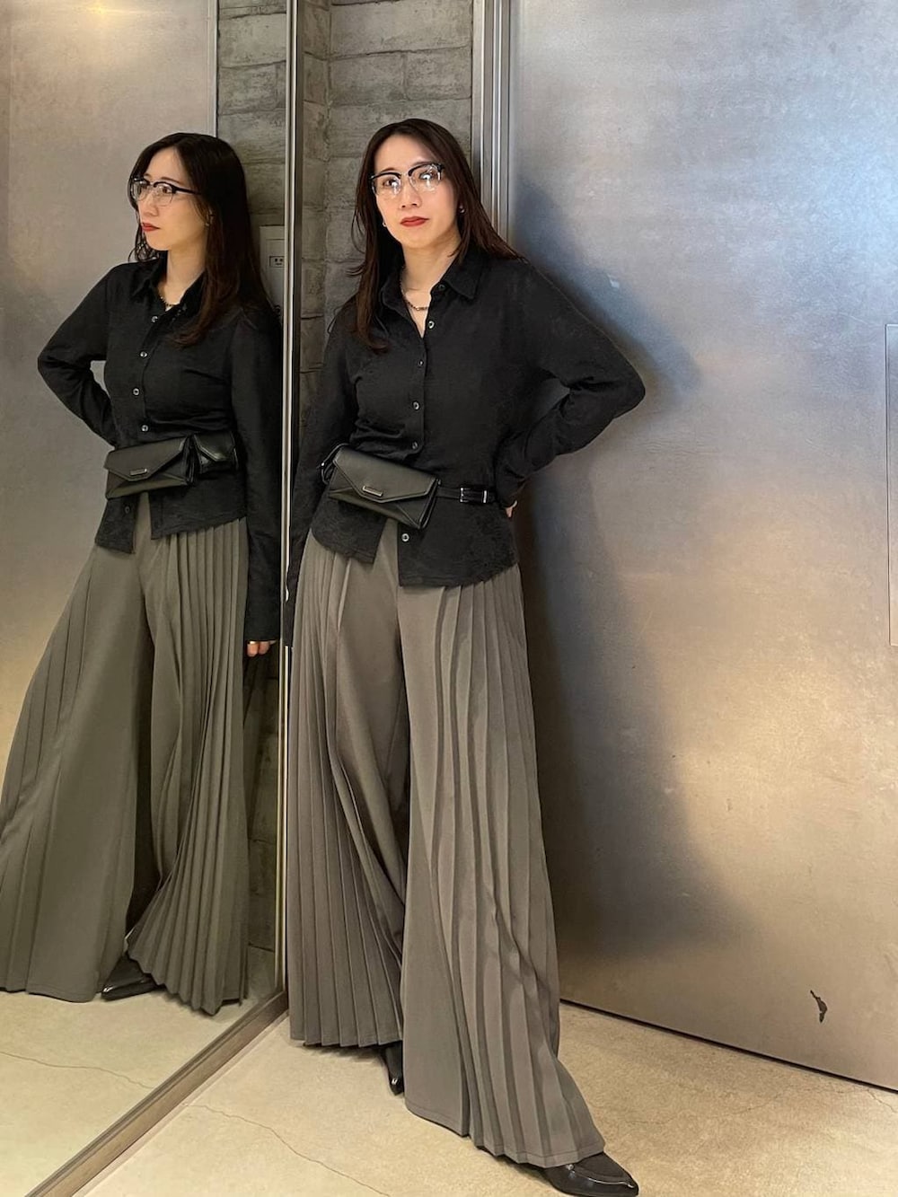 ブラック系のサンダル、ブラック系のボディバッグ/ウエストポーチ、グレー系のスラックスを着用したレディースの春コーディネートの2枚目の写真