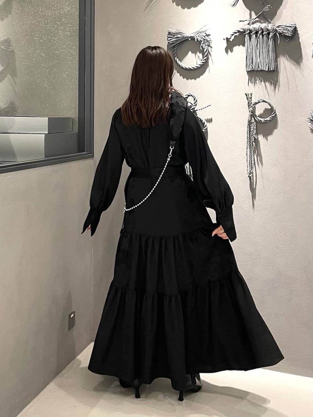 ブラック系のブーツ、ブラック系のワンピース、ブラック系のスマホグッズを着用したレディースの冬コーディネートの3枚目の写真