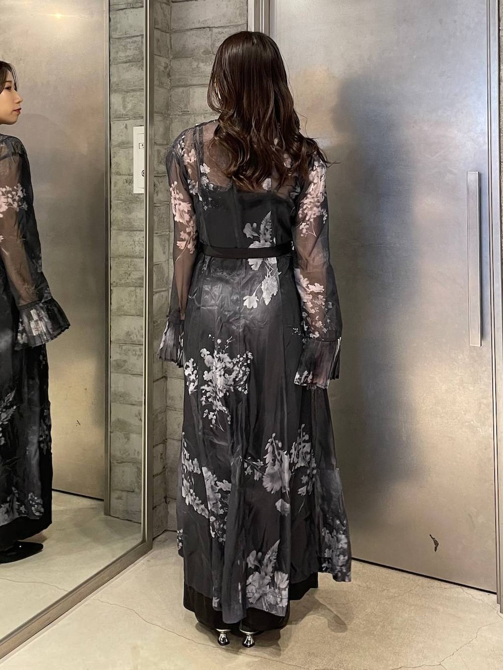 ブラック系のパンプス、ブラック系のワンピース、ゴールド系のネックレスを着用したレディースの冬コーディネートの4枚目の写真