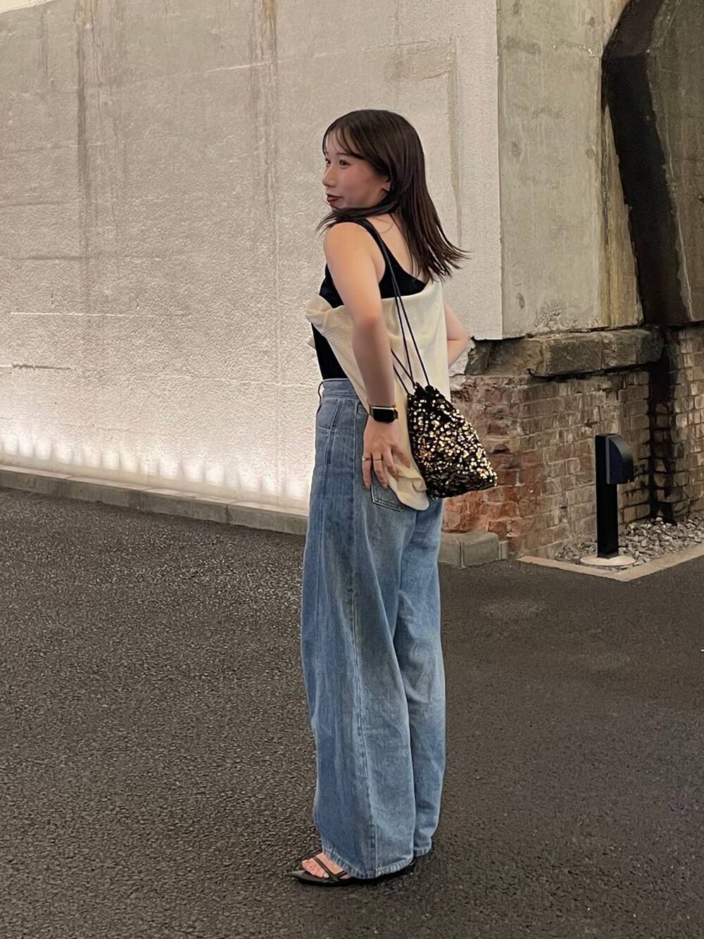 ブルー系のデニムパンツ、ブラック系のサンダルを着用したレディースの秋コーディネートの2枚目の写真