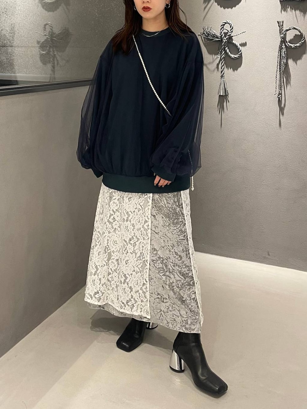 ブラック系のブーツ、グリーン系のスウェット、グレー系のスカートを着用したレディースの秋コーディネートの3枚目の写真