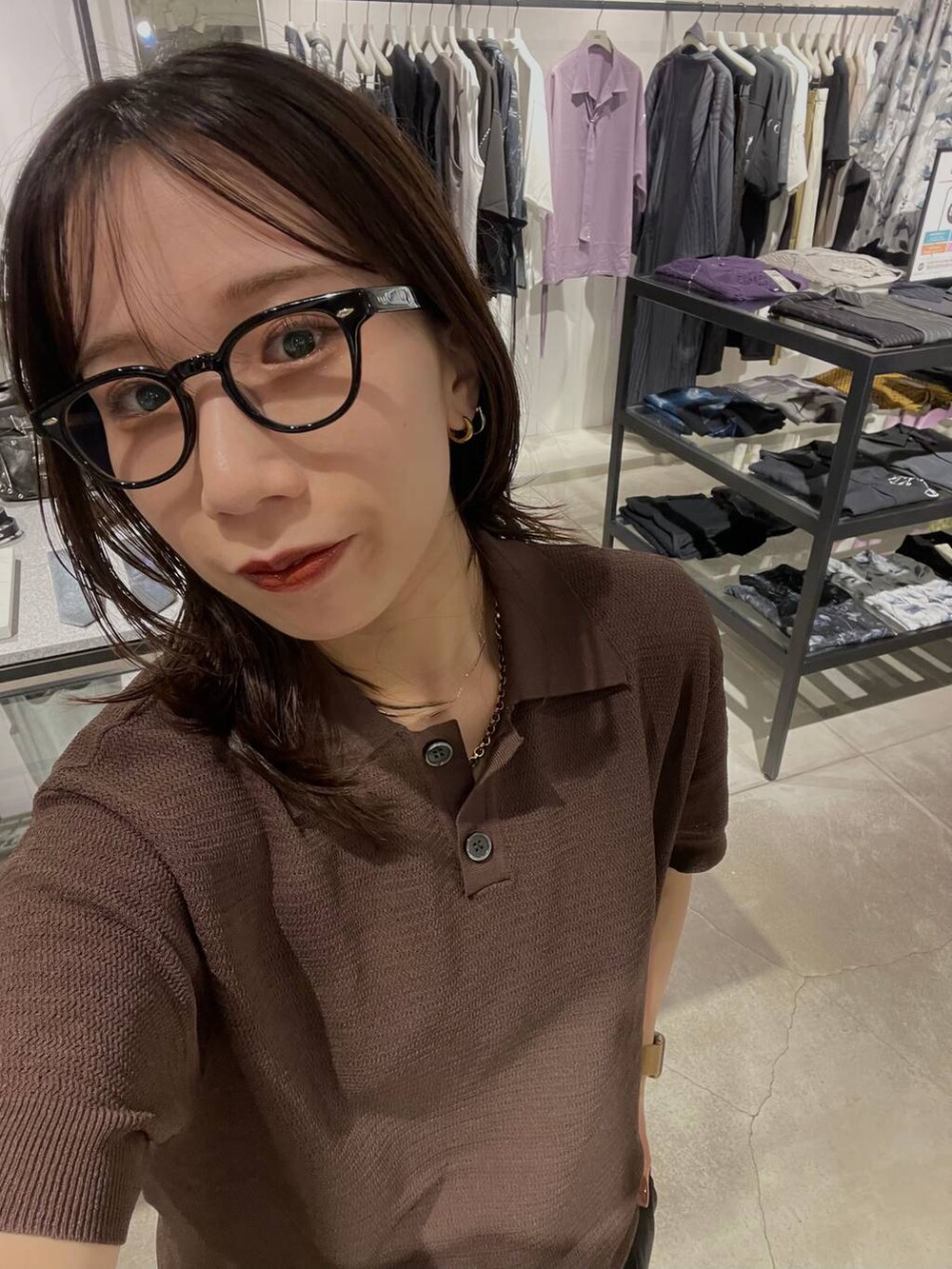 ブラウン系のポロシャツを着用したレディースの夏コーディネートの4枚目の写真