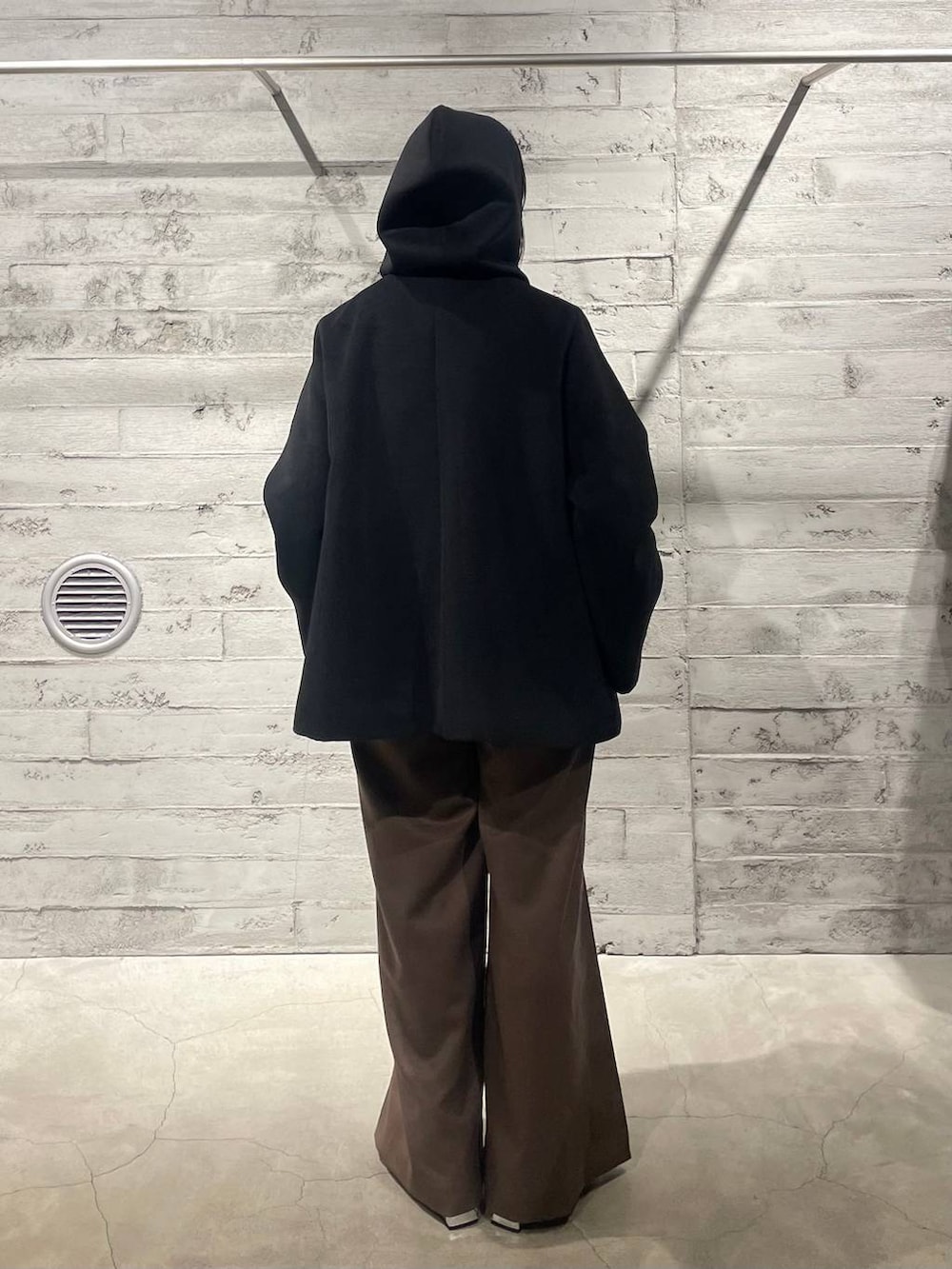 ブラック系のブーツ、ブラック系のノーカラーコート、ブラウン系のその他パンツを着用したレディースの冬コーディネートの5枚目の写真