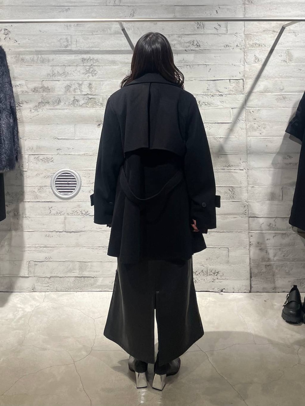 ブラック系のトレンチコート、ブラック系のブーツ、レッド系のニット/セーターを着用したレディースの秋コーディネートの4枚目の写真