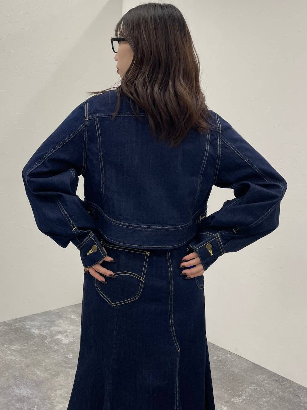 ブルー系のデニムジャケット、ブラック系のブーツ、ブルー系のデニムスカートを着用したレディースの秋コーディネートの6枚目の写真