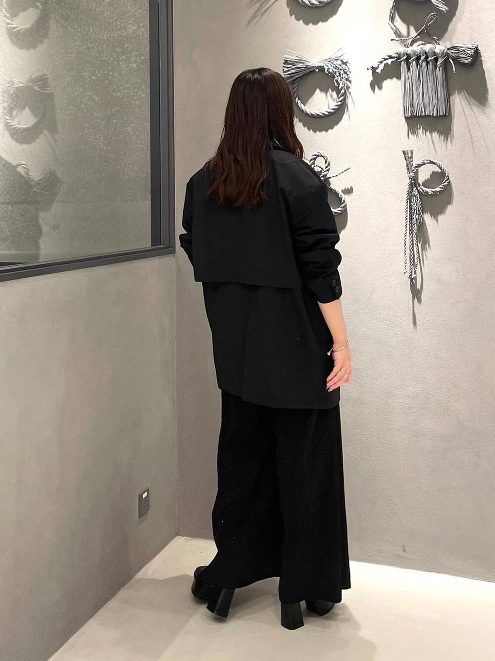 ホワイト系のタンクトップ、ブラック系のブーツ、ブラック系のその他パンツを着用したレディースの秋コーディネートの3枚目の写真