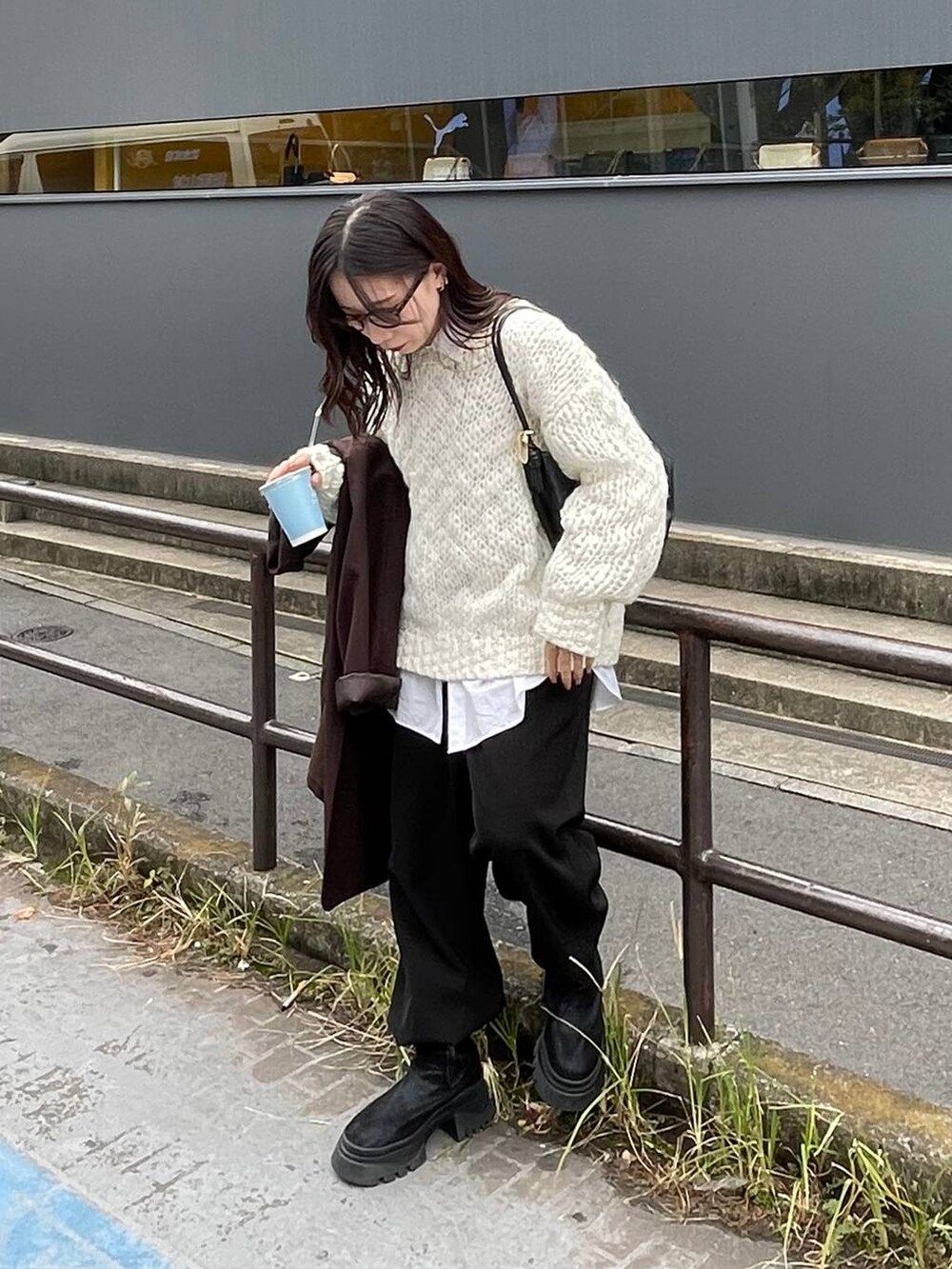 ブラック系のショルダーバッグ、ホワイト系のニット/セーターを着用したレディースの秋コーディネートの2枚目の写真