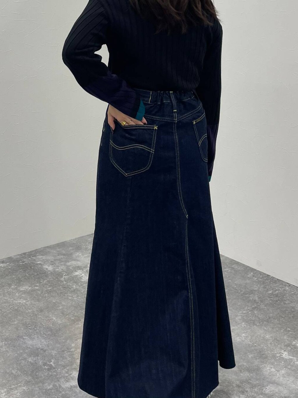 ブルー系のデニムジャケット、ブラック系のブーツ、ブルー系のデニムスカートを着用したレディースの秋コーディネートの5枚目の写真