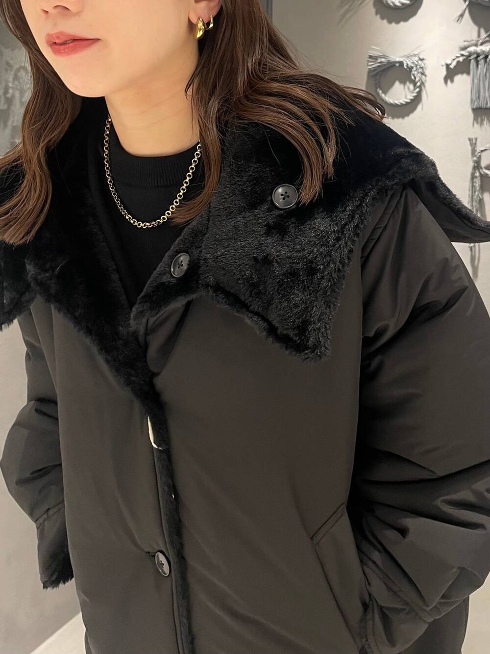 ブラック系のダウンジャケット/コート、ブラック系のブーツ、ブラック系のニット/セーターを着用したレディースの秋コーディネートの6枚目の写真