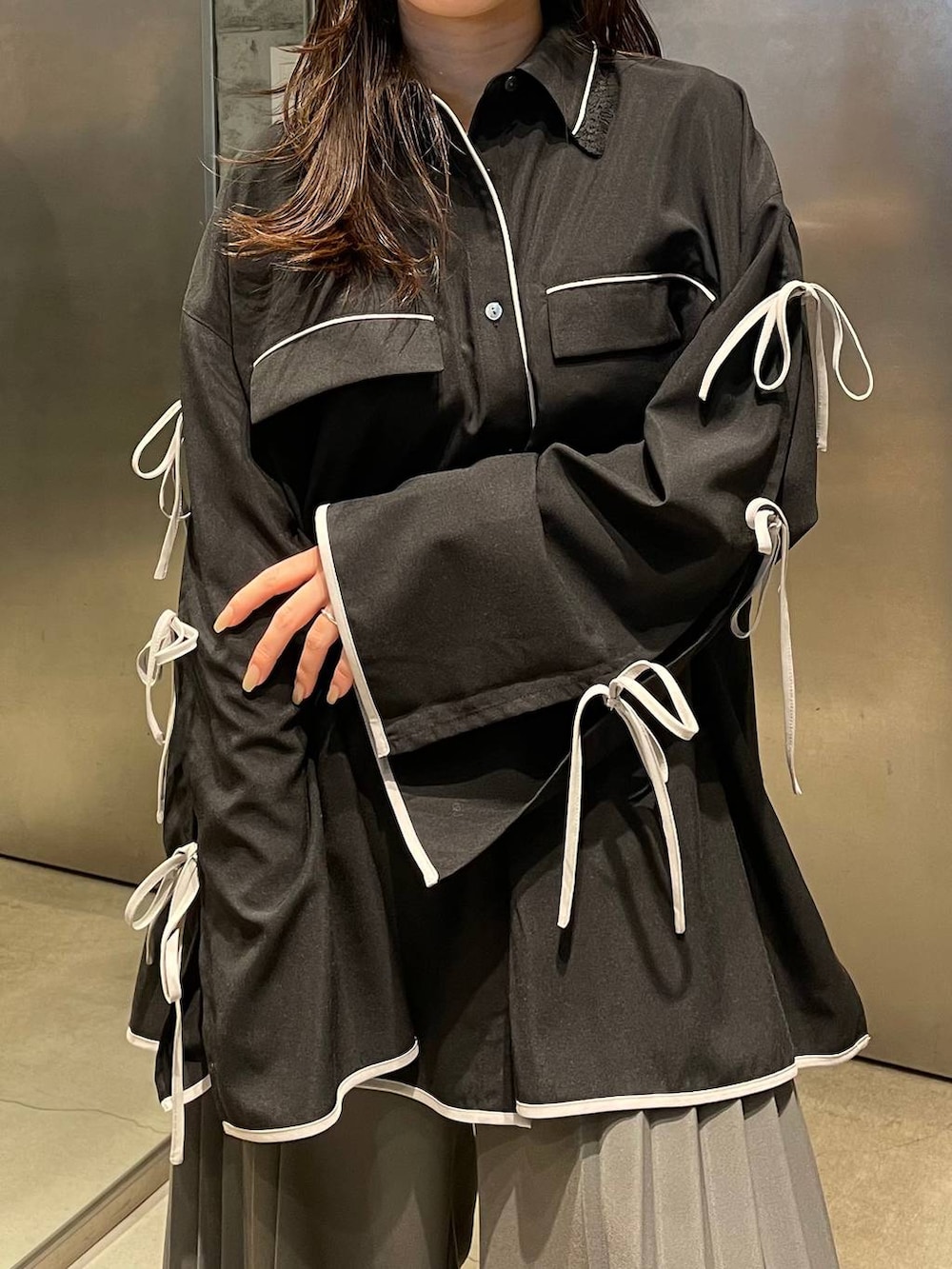 ブラック系のサンダル、グレー系のスラックス、ブラック系のシャツ/ブラウスを着用したレディースの春コーディネートの5枚目の写真