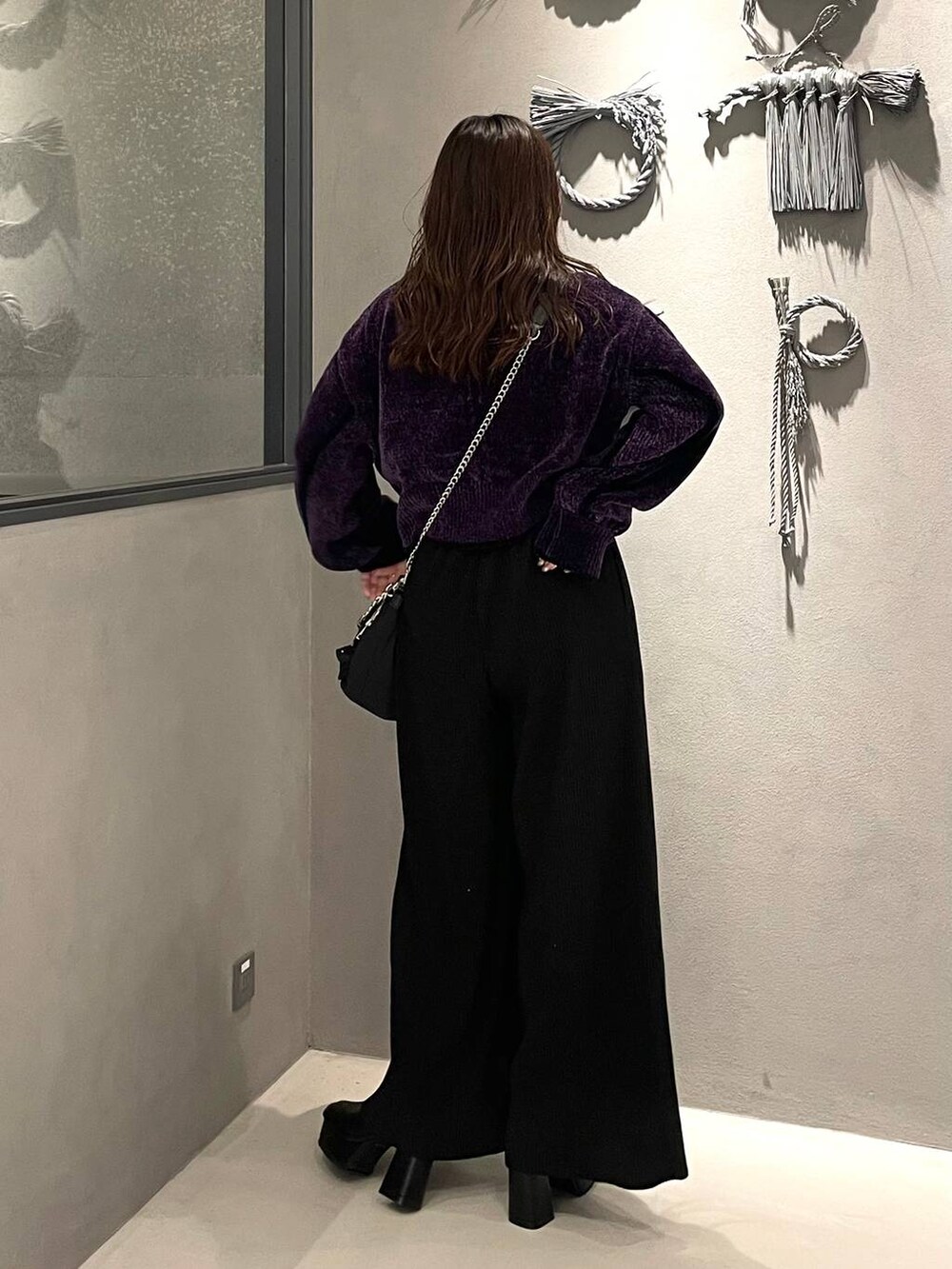 ブラック系のショルダーバッグ、ブラック系のブーツ、パープル系のカーディガン/ボレロを着用したレディースの秋コーディネートの3枚目の写真