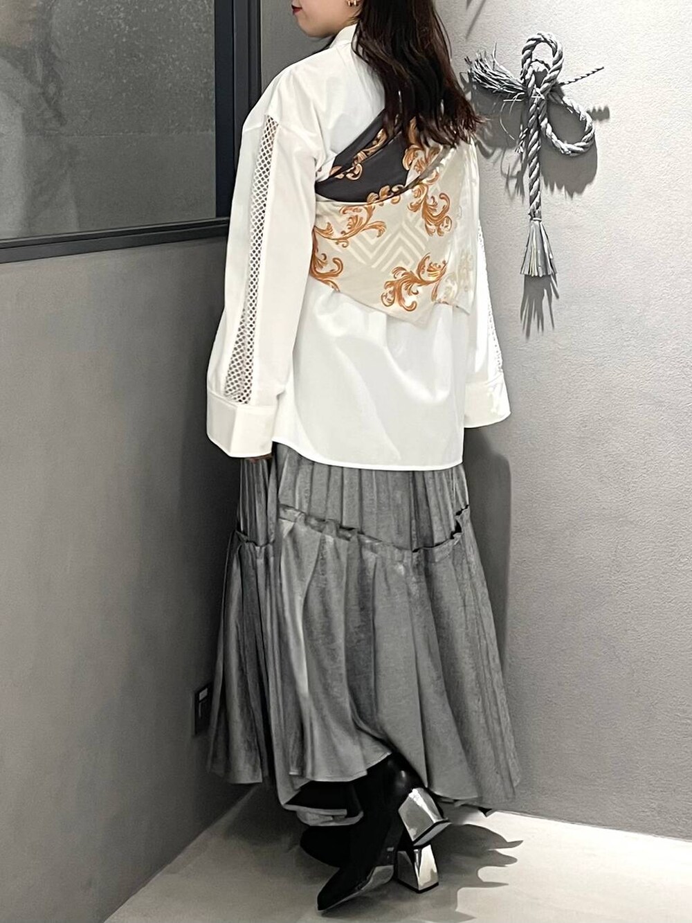 ブラック系のブーツ、ホワイト系のシャツ/ブラウス、シルバー系のスカートを着用したレディースの春コーディネートの3枚目の写真