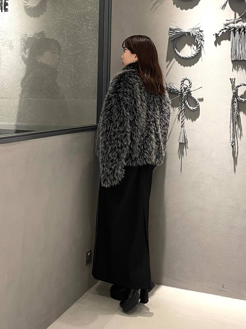 ブラック系のブーツ、グレー系のブルゾン、ブラック系のスカートを着用したレディースの秋コーディネートの2枚目の写真