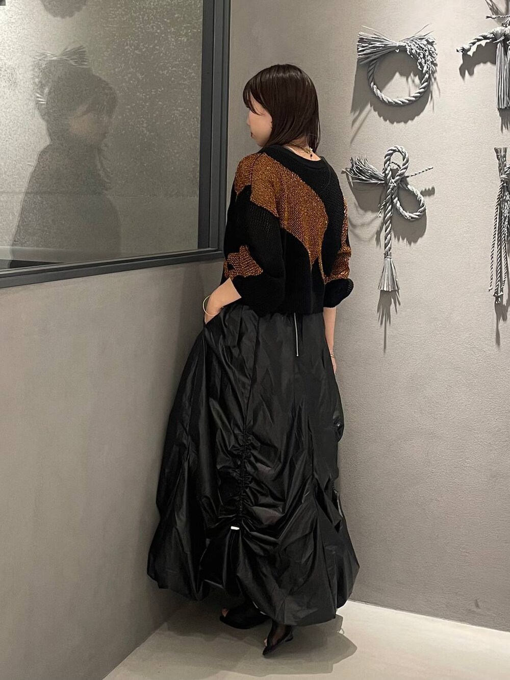 ブラック系のサンダル、オレンジ系のカーディガン/ボレロ、グレー系のタンクトップを着用したレディースの夏コーディネートの2枚目の写真