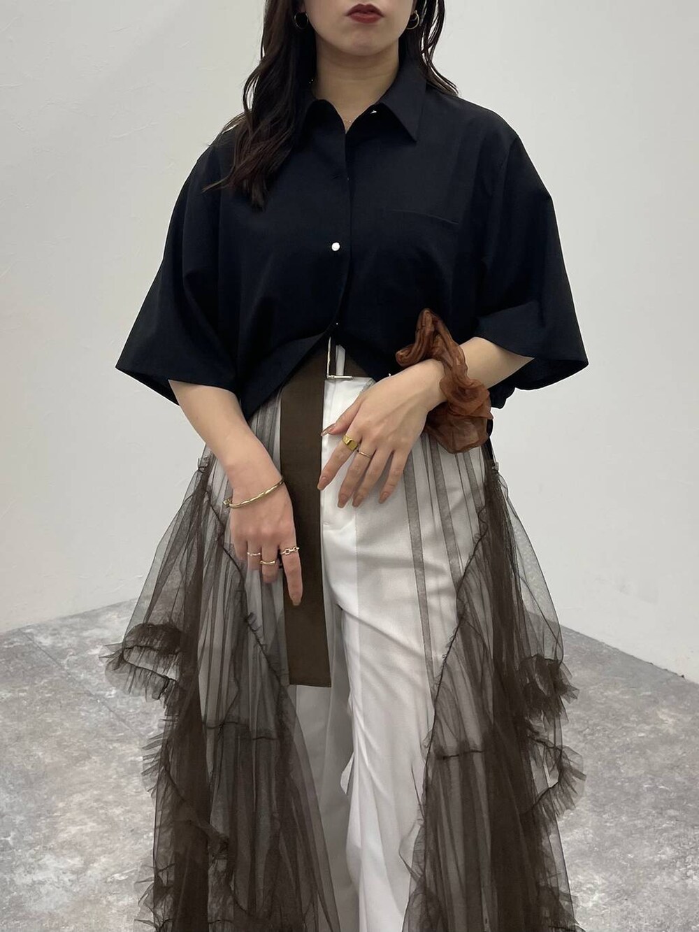 ブラウン系のスカート、ブラック系のサンダル、ホワイト系のその他パンツを着用したレディースの夏コーディネートの4枚目の写真