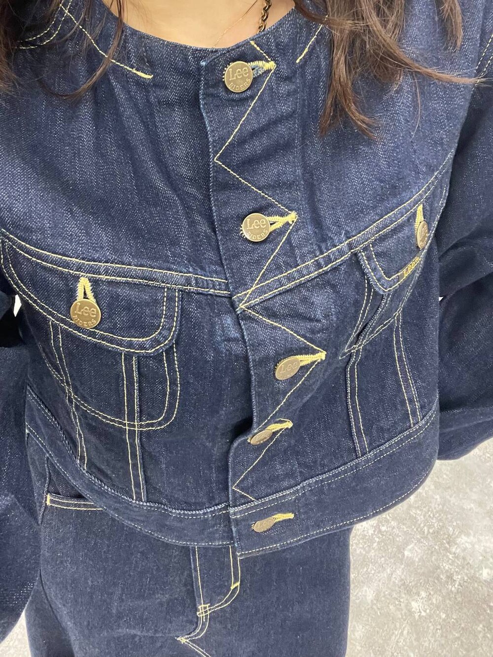 ブルー系のデニムジャケット、ブラック系のブーツ、ブルー系のデニムスカートを着用したレディースの秋コーディネートの6枚目の写真