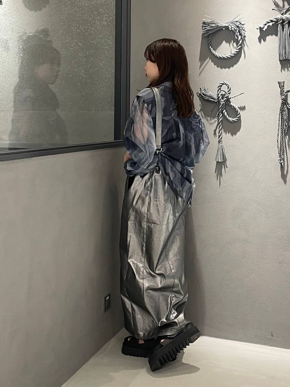 ブラック系のサンダル、シルバー系のスカートを着用したレディースの春コーディネートの2枚目の写真