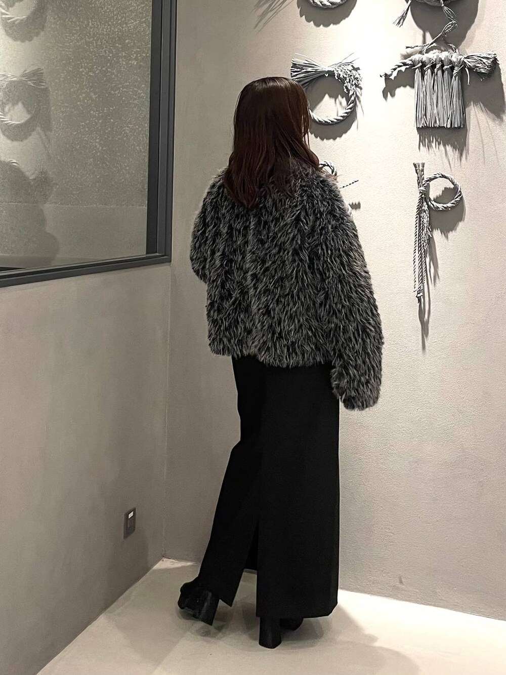 ブラック系のブーツ、グレー系のブルゾン、ブラック系のスカートを着用したレディースの秋コーディネートの3枚目の写真