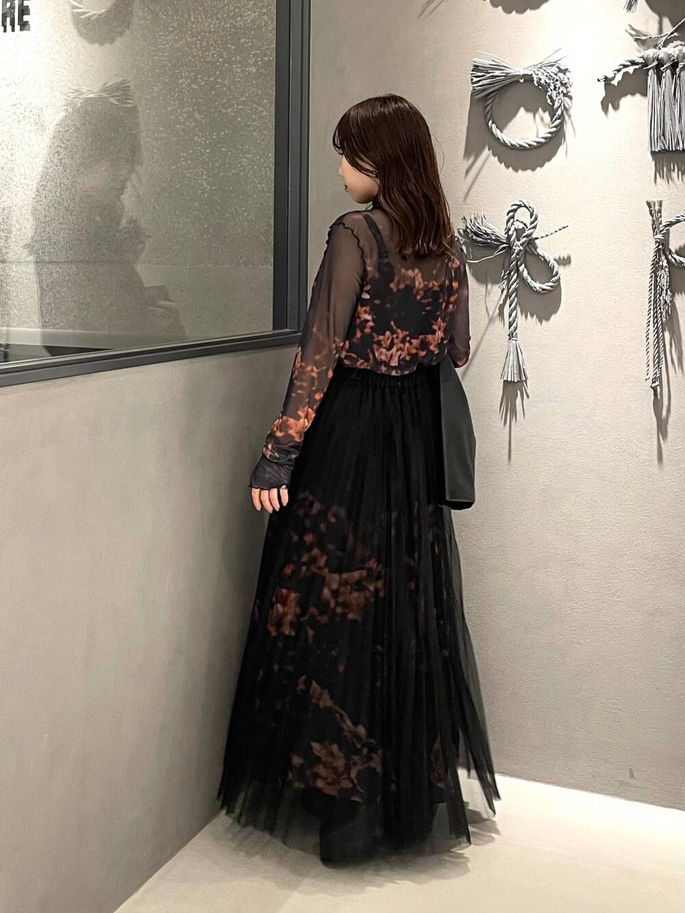 ブラック系のブーツ、オレンジ系のスカート、オレンジ系のTシャツ/カットソーを着用したレディースの秋コーディネートの2枚目の写真