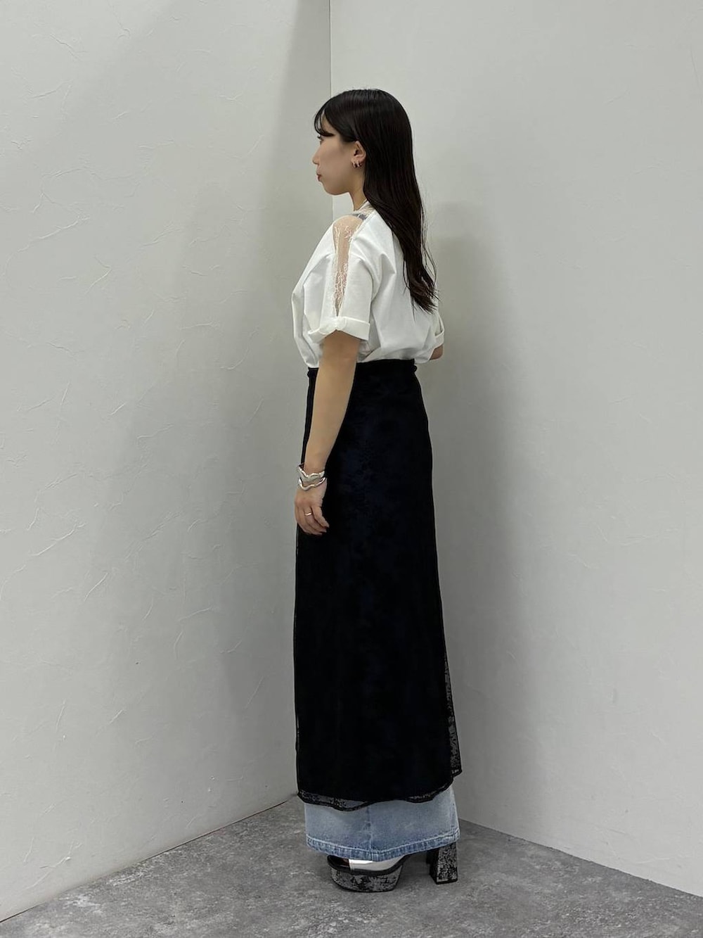 シルバー系のサンダル、ホワイト系のTシャツ/カットソー、ブルー系のデニムパンツを着用したレディースの春コーディネートの2枚目の写真