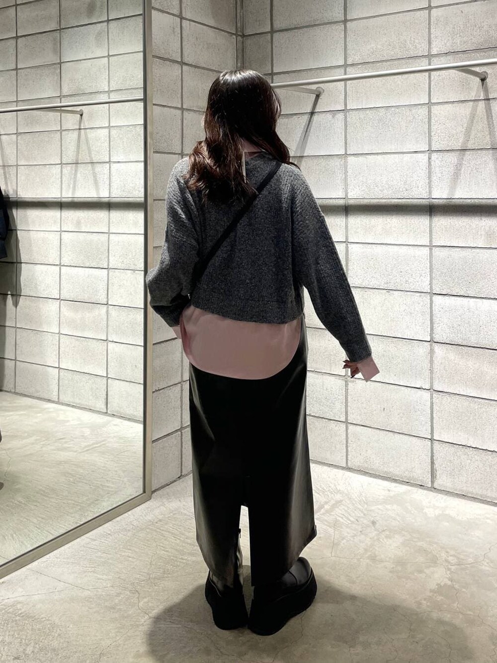 ピンク系のニット/セーター、ブラック系のブーツ、ブラック系のショルダーバッグを着用したレディースの冬コーディネートの2枚目の写真
